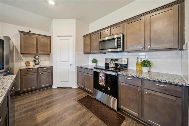 kitchen with stainless steel appliances, light stone counters, dark brown cabinetry, dark hardwood / wood-style flooring, and decorative backsplash