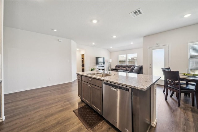 kitchen featuring dark wood-type flooring, a kitchen island with sink, dishwasher, and sink