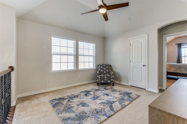 living area featuring carpet, lofted ceiling, and ceiling fan