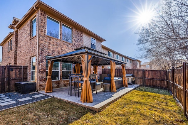 rear view of house with a gazebo, outdoor lounge area, a patio area, and a lawn