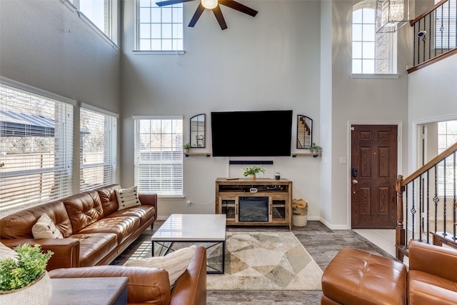 living room with a towering ceiling and ceiling fan