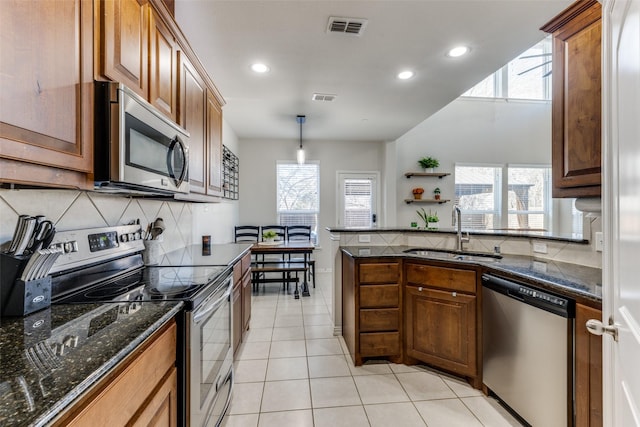 kitchen featuring light tile patterned flooring, sink, decorative light fixtures, stainless steel appliances, and decorative backsplash