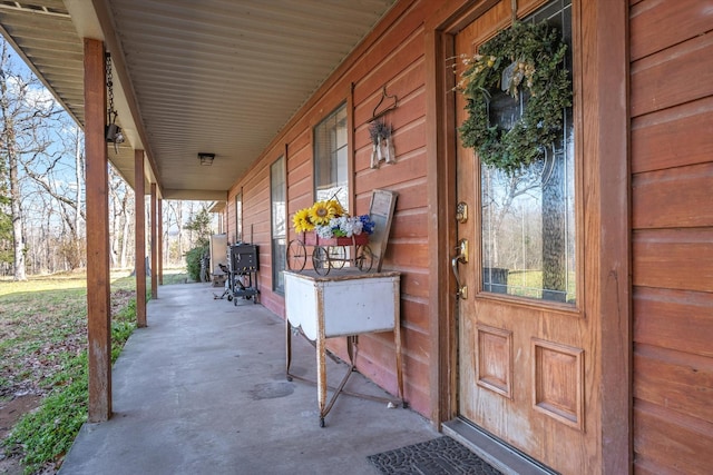 view of exterior entry featuring covered porch