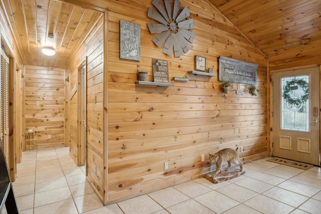 mudroom with lofted ceiling, light tile patterned floors, wood ceiling, and wood walls