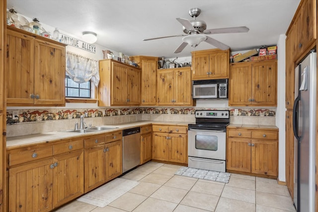 kitchen with sink, light tile patterned floors, ceiling fan, backsplash, and stainless steel appliances