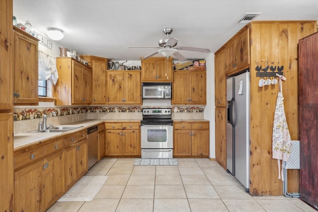 kitchen with ceiling fan, stainless steel appliances, sink, and light tile patterned floors