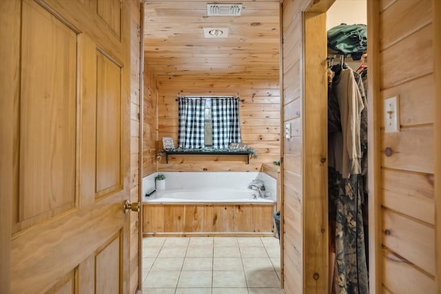 bathroom featuring lofted ceiling, wood walls, wooden ceiling, a bathtub, and tile patterned flooring