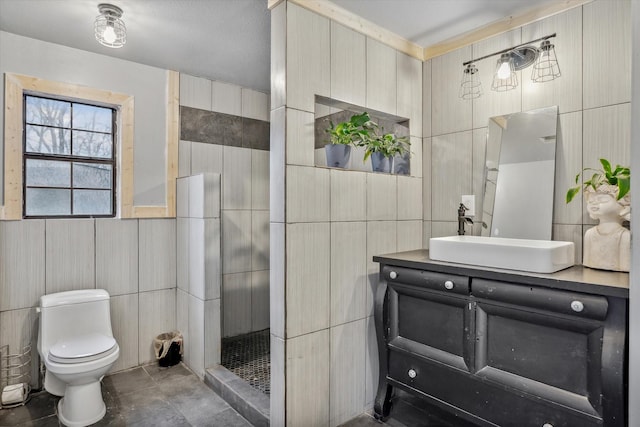 bathroom featuring vanity, tile walls, and toilet