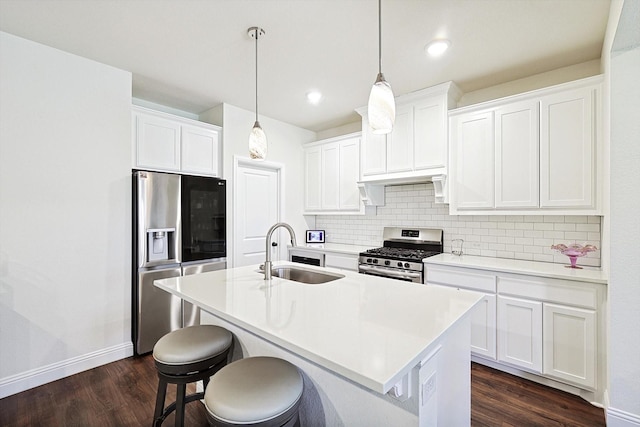 kitchen featuring hanging light fixtures, appliances with stainless steel finishes, sink, and white cabinets