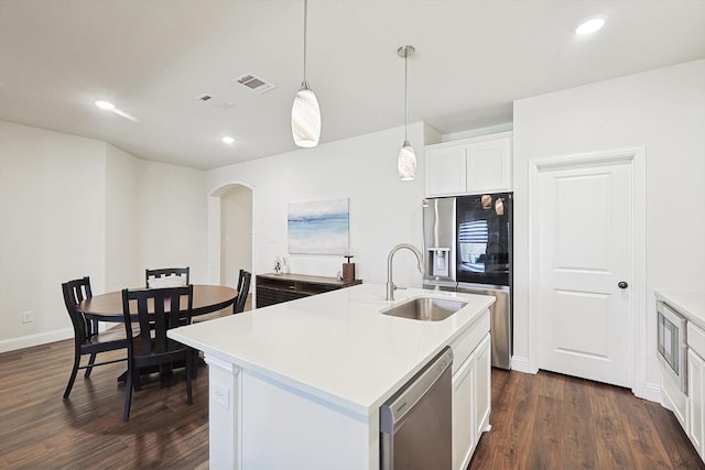 kitchen featuring decorative light fixtures, white cabinetry, sink, a kitchen island with sink, and stainless steel appliances