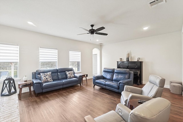 living room with dark wood-type flooring and ceiling fan