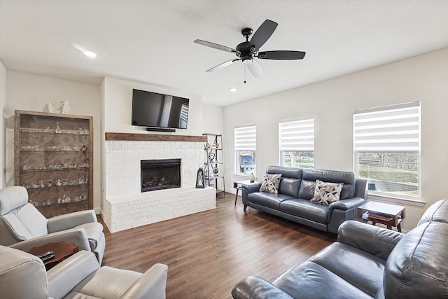 living room with dark hardwood / wood-style flooring, a fireplace, and ceiling fan