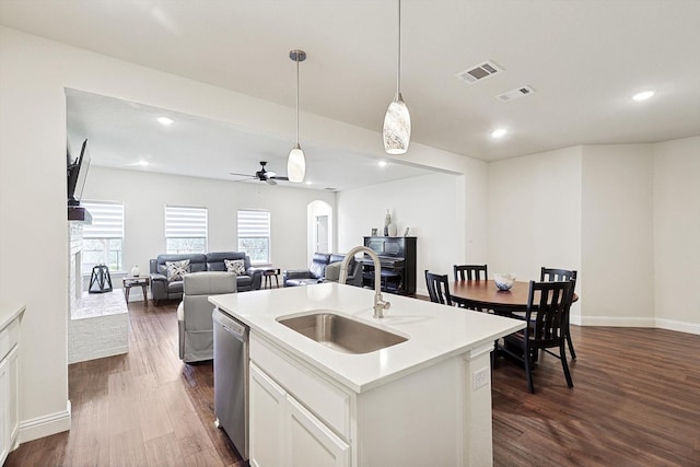 kitchen featuring sink, decorative light fixtures, dishwasher, an island with sink, and white cabinets