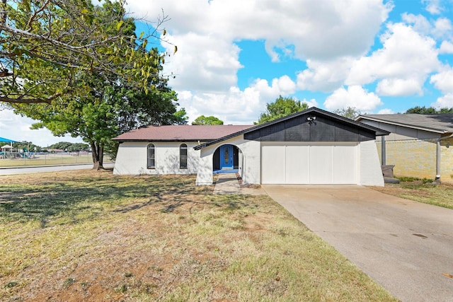 ranch-style home with a garage and a front lawn