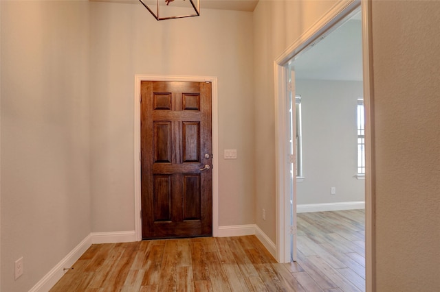 foyer with light wood-style flooring and baseboards