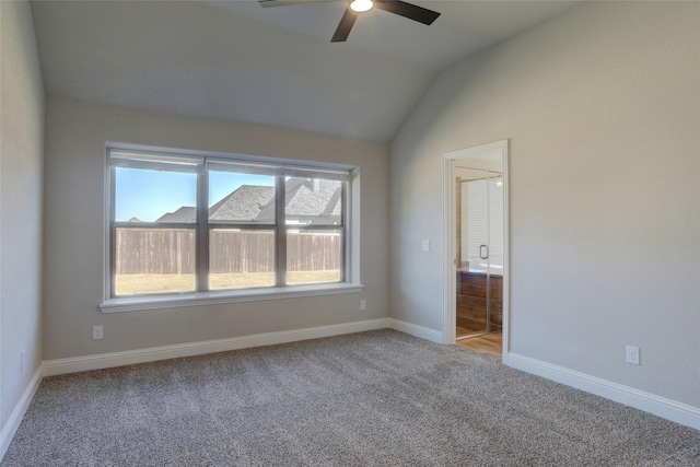 unfurnished bedroom with baseboards, a ceiling fan, connected bathroom, vaulted ceiling, and carpet floors