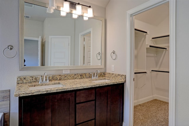 full bath featuring visible vents, a sink, and a spacious closet