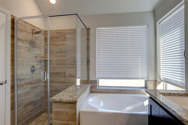 bathroom with a stall shower, a garden tub, and vanity