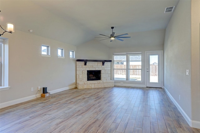 unfurnished living room featuring baseboards, visible vents, a ceiling fan, wood finished floors, and a fireplace