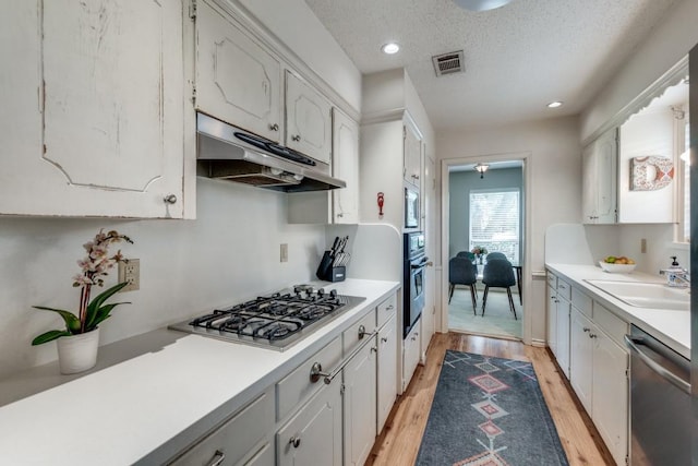 kitchen with sink, stainless steel appliances, and white cabinets