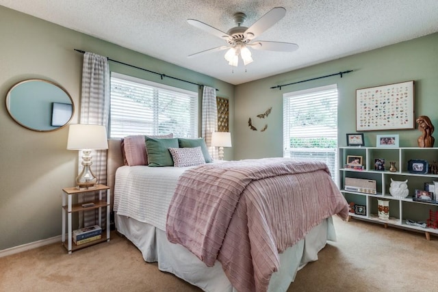 bedroom with multiple windows, light colored carpet, and a textured ceiling