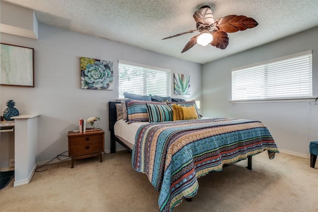 carpeted bedroom with ceiling fan and a textured ceiling