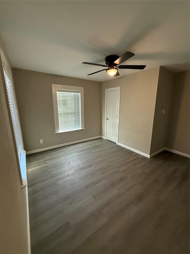 empty room with dark hardwood / wood-style floors and ceiling fan