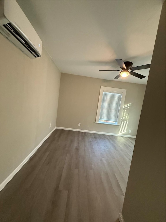 unfurnished room with wood-type flooring, a wall unit AC, and ceiling fan