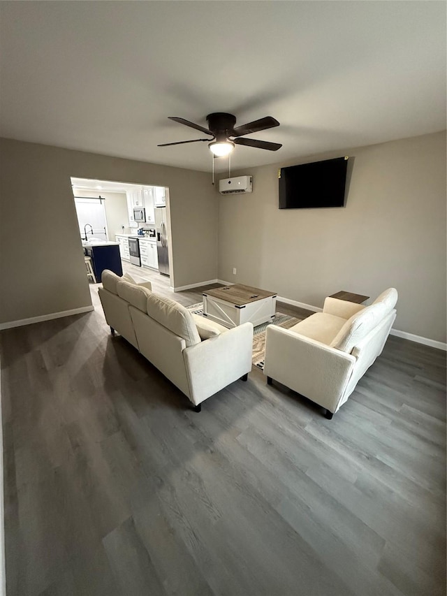 living room featuring sink, wood-type flooring, a wall unit AC, and ceiling fan