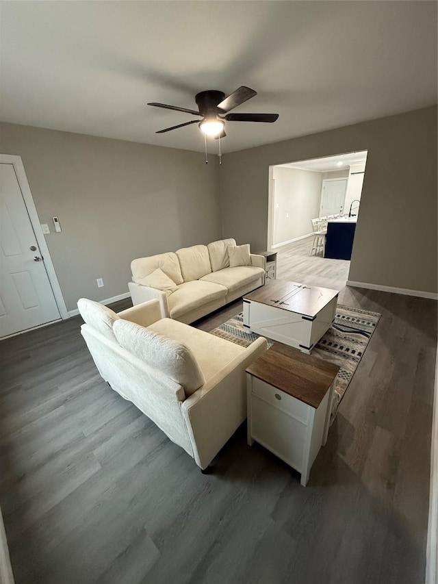 living room with dark hardwood / wood-style flooring and ceiling fan