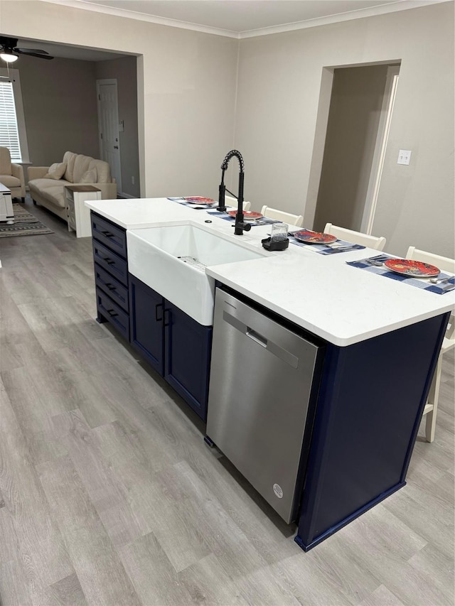 kitchen with crown molding, blue cabinetry, dishwasher, light hardwood / wood-style floors, and a center island with sink