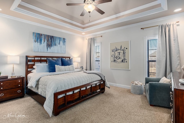 carpeted bedroom featuring crown molding, ceiling fan, and a raised ceiling