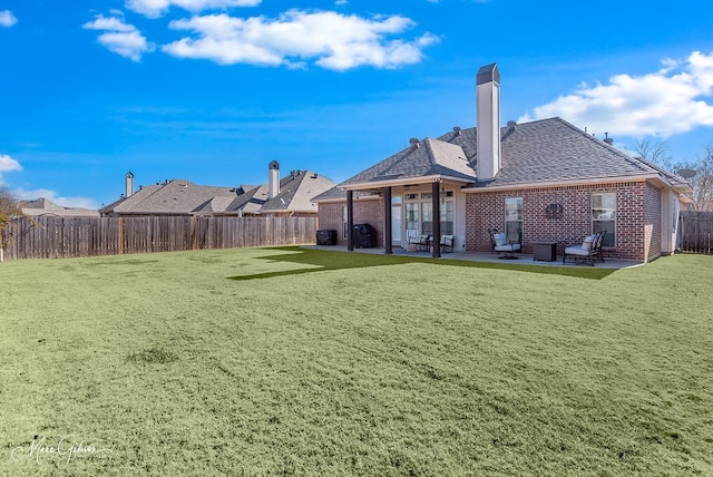 rear view of house with a patio and a lawn