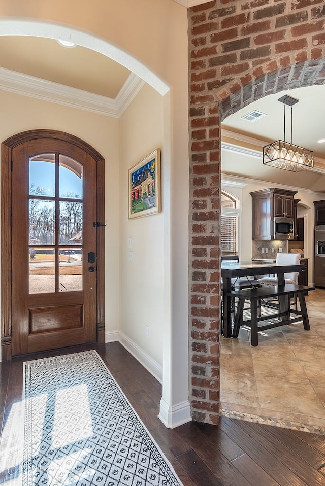 foyer entrance with dark hardwood / wood-style flooring and ornamental molding