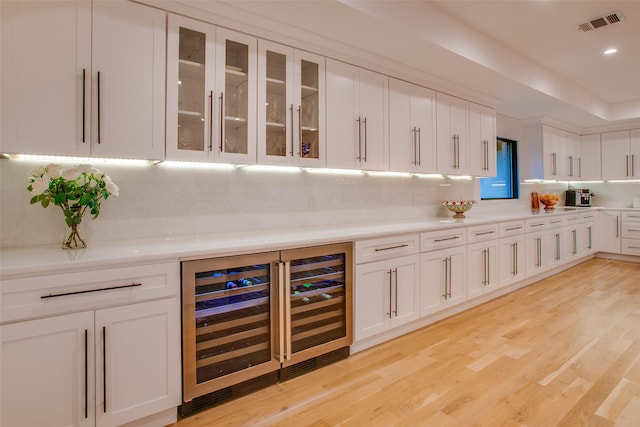 kitchen featuring beverage cooler, white cabinets, and light wood-type flooring