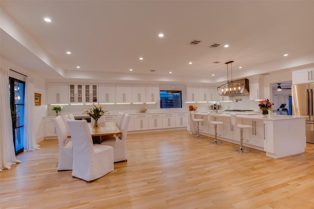 dining space featuring ceiling fan, sink, and light wood-type flooring