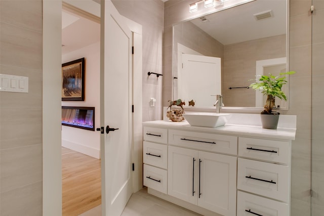 bathroom featuring vanity and tile walls