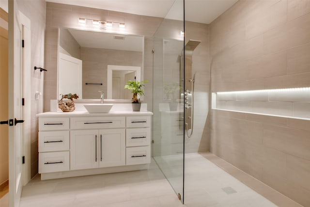 bathroom with vanity, tile walls, and a tile shower