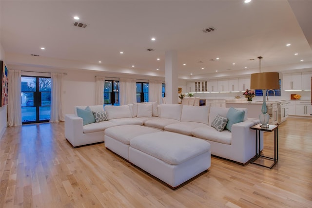 living room with sink and light wood-type flooring