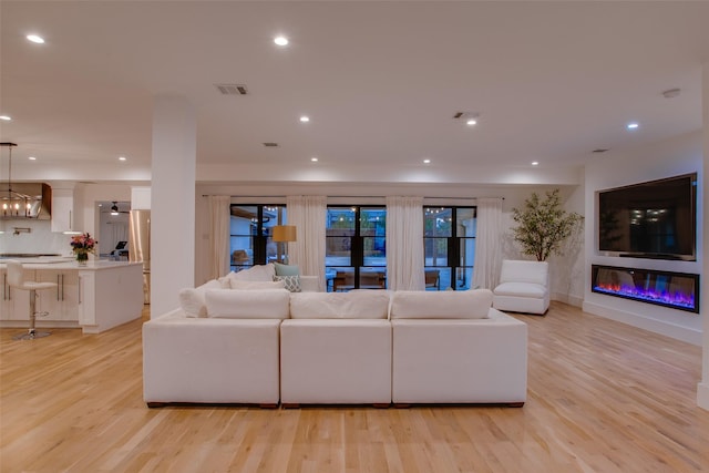 living room featuring a chandelier and light hardwood / wood-style floors