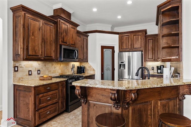 kitchen featuring stainless steel appliances, light stone counters, dark brown cabinetry, and a kitchen bar