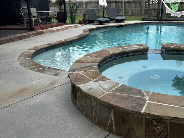 view of pool featuring an in ground hot tub and a patio