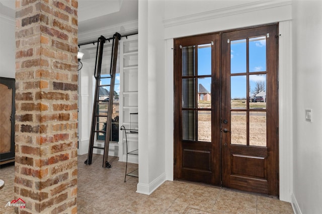 entrance foyer with french doors, a healthy amount of sunlight, and crown molding