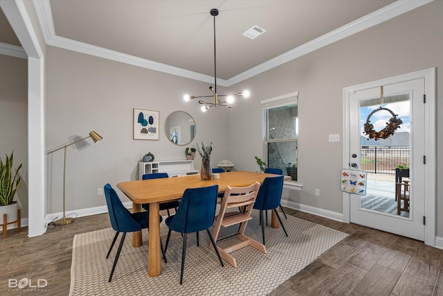 dining area featuring crown molding, dark hardwood / wood-style flooring, and a notable chandelier