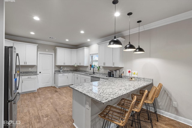 kitchen featuring pendant lighting, a breakfast bar area, appliances with stainless steel finishes, white cabinetry, and kitchen peninsula