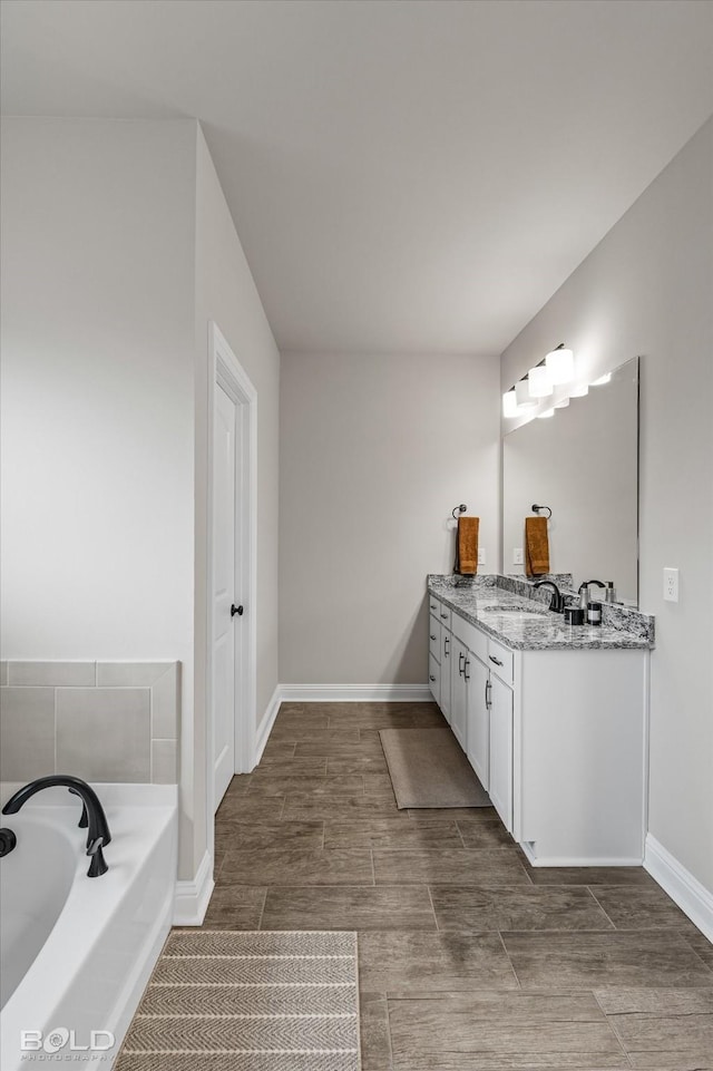 bathroom featuring vanity and a tub to relax in