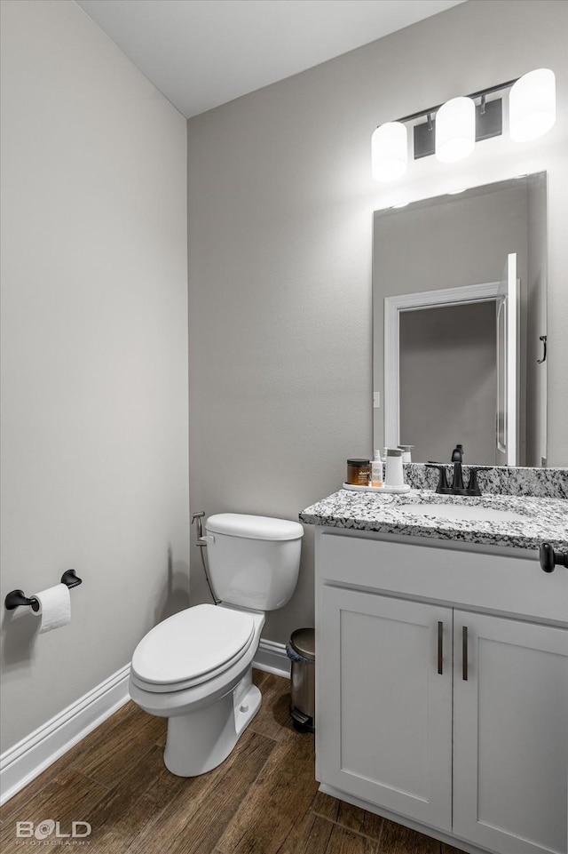 bathroom featuring vanity, hardwood / wood-style floors, and toilet