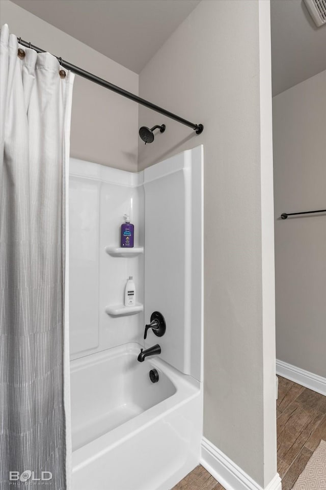 bathroom featuring hardwood / wood-style flooring and shower / bath combo with shower curtain