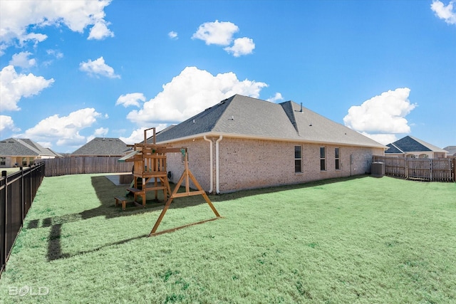 rear view of house featuring cooling unit, a playground, and a lawn