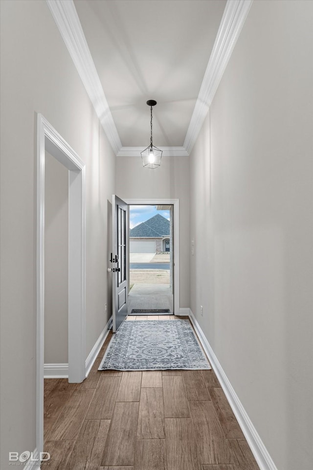 doorway with hardwood / wood-style floors and ornamental molding